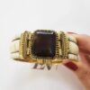 Pulseira Tibetana Rígida Osso Larga Chata Meia Cana Dourada Pedra Mineral Central Quadrada cor Marrom Escuro Fecho de Encaixe por Pino 18cm