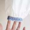Bata Feminina Branca Bordado Azul Frontal Manga e Punho Decote Redondo Abertura Colo Manga Longa